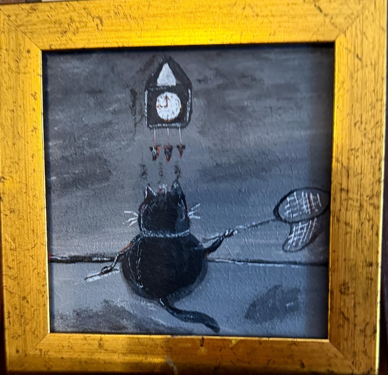 Puede incluir: Una pintura caprichosa en un marco dorado representa un gato negro con una red de mariposas, alcanzando un reloj de cuco. El reloj est&aacute; encima del gato, y el fondo es gris apagado. La obra de arte tiene un estilo juguet&oacute;n y caricaturesco.