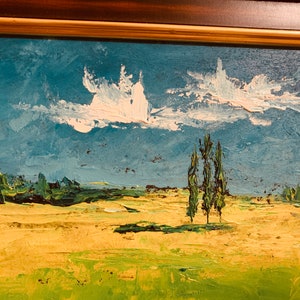 May include: A painting of a landscape with a blue sky, white clouds, and three green trees in the foreground. The field is a yellow-green color.