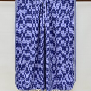 May include: A blue and white patterned beach towel with fringe on the bottom edge.