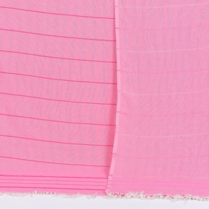 May include: A pink striped cotton towel with a fringe border.