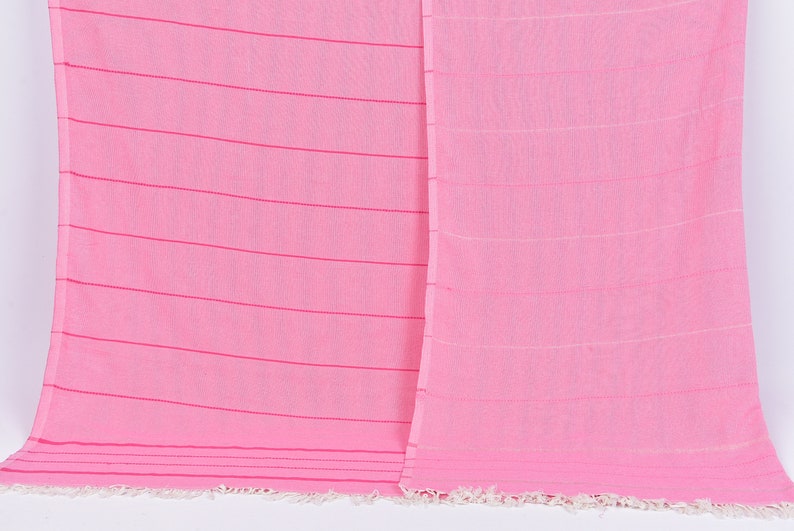 May include: A pink striped cotton towel with a fringe border.