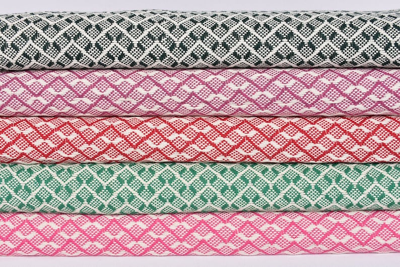 May include: Five fabric swatches featuring a geometric diamond pattern. The swatches are in shades of green, pink, red, and purple.