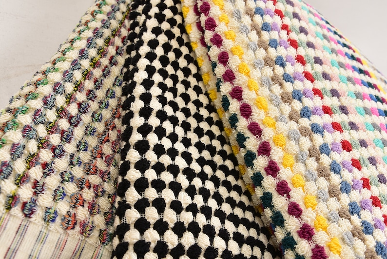 May include: Four different bath mats with various patterns. The first mat has a black and white checkered pattern. The second mat has a colorful pattern with red, blue, yellow, and green. The third mat has a white background with a colorful pattern of red, yellow, blue, and purple. The fourth mat has a white background with a colorful pattern of red, yellow, blue, and green.