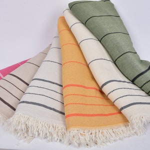 May include: Five striped towels in different colors, including pink, beige, yellow, and green, with black stripes and white fringe.
