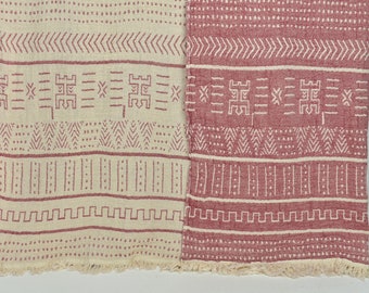 May include: A cream and burgundy woven throw blanket with a geometric pattern. The blanket has a fringe border.