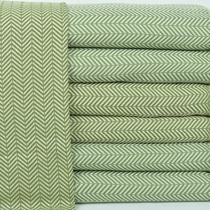 May include: A stack of green and white herringbone patterned throw blankets with fringe edges.