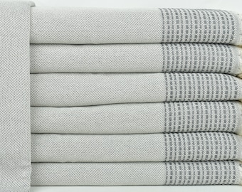May include: A stack of six gray and white striped towels with fringed edges. The towels are made of a soft, absorbent material.