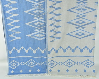 May include: Two patterned towels, one blue with white geometric designs and one white with blue geometric designs.