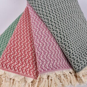May include: Four woven cotton throws with fringe edges. The throws are in shades of green, red, purple, and black.