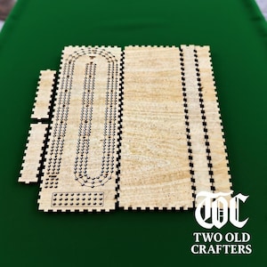 Può includere: Un set da gioco da tavolo di cribbage in legno con finitura a venatura chiara. Il set include la tavola principale, pezzi laterali più piccoli e una pista per i pioli. La tavola ha una serie di fori per il punteggio.