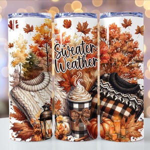 Puede incluir: Un vaso blanco con un diseño de temática otoñal. El diseño incluye un suéter acogedor, hojas de otoño, calabazas, una taza de café y las palabras "Sweater Weather". El vaso está decorado con colores cálidos como el naranja, el marrón y el crema.