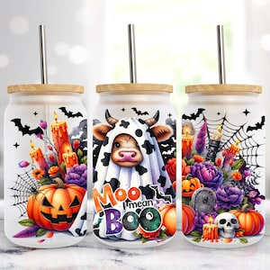 Könnte beinhalten: Drei Glasbecher mit Bambusdeckeln und Metallstrohhalmen. Jeder hat ein Halloween-Design mit Kürbissen, Kerzen, Fledermäusen, Spinnweben und Blumen. Ein Becher hat eine Kuh in einem Geisterkostüm mit dem Text "Moo I mean Boo".