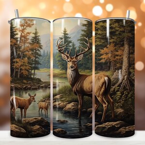 Könnte beinhalten: Ein Edelstahlbecher mit einem farbenfrohen Bild eines Hirsches, der in einem Waldstrom steht. Der Hirsch ist braun mit großen Geweihen. Der Hintergrund ist ein üppiger grüner Wald mit blauem Himmel.