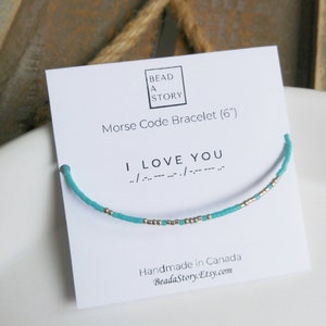 May include: A turquoise and silver beaded bracelet with the message "I LOVE YOU" in Morse code. The bracelet is 6 inches long and is handmade in Canada.