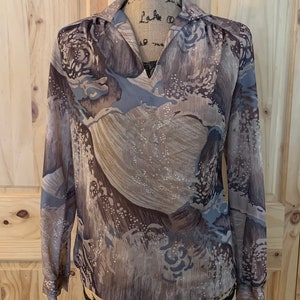 May include: A brown and blue patterned long-sleeved blouse with a V-neck collar.