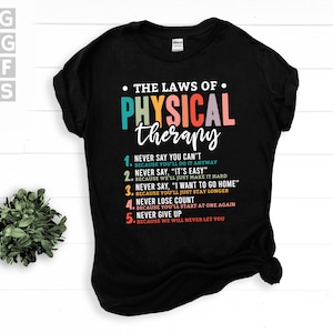 Puede incluir: Camiseta negra con el texto "THE LAWS OF PHYSICAL therapy" en colores arcoíris. El texto va seguido de una lista de cinco reglas con el texto "NEVER SAY YOU CAN'T BECAUSE YOU'LL DO IT ANYWAY" y otras cuatro reglas similares.