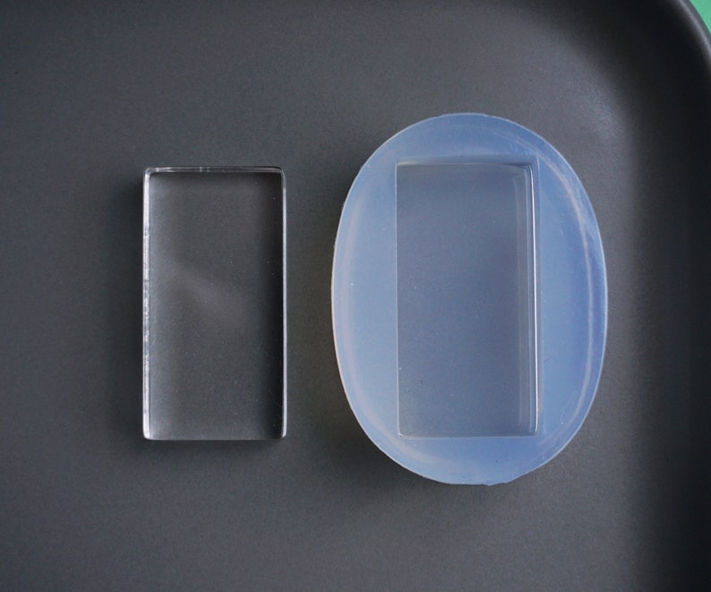 Peut inclure: Deux moules en r&eacute;sine transparente pour la cr&eacute;ation. Un moule est rectangulaire et l'autre est ovale avec une d&eacute;coupe rectangulaire.
