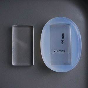 Peut inclure: Un moule en silicone rectangulaire transparent pour la coul&eacute;e de r&eacute;sine. Le moule mesure 23 mm de large et 44 mm de haut.
