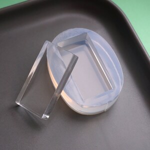 Peut inclure: Deux moules en silicone transparents pour la coul&eacute;e de r&eacute;sine. Un moule est rectangulaire et l'autre est de forme ovale.