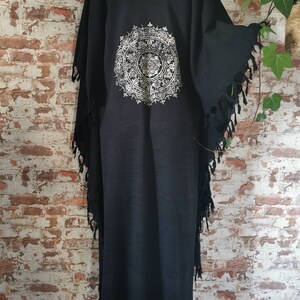 K&ouml;nnte beinhalten: Schwarzer Baumwoll-Kimono mit einem wei&szlig;en Mandala-Muster auf der R&uuml;ckseite. Der Kimono hat Fransen an den R&auml;ndern.