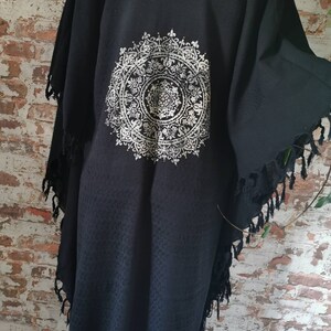 K&ouml;nnte beinhalten: Schwarzer Kimono mit einem silbernen Mandala-Design auf der R&uuml;ckseite. Der Kimono hat einen Fransenbesatz an Saum und &Auml;rmeln.