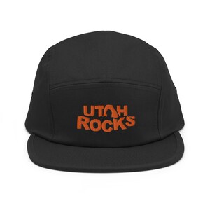 May include: A black 5-panel cap with an orange embroidered logo that says "UTAH ROCKS".