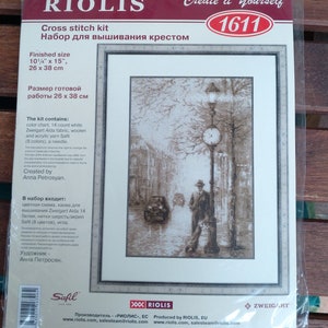 May include: Cross stitch kit featuring a black and white image of a man walking down a street with a street lamp and clock. The kit includes Zweigart Aida fabric, wool and acrylic yarn, and a needle. The finished size is 26 cm by 38 cm. The kit is by Riolis and the design is by Anna Petrosyan.