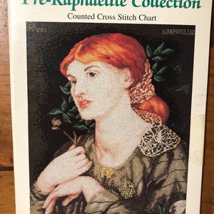 Könnte beinhalten: Ein Zählkreuzstich-Diagramm mit einer Frau mit roten Haaren, die ein grünes Kleid mit einem Spitzenkragen trägt. Das Diagramm trägt den Titel "Pre-Raphaelite Collection" und ist Teil von "The Ultimate Cross Stitch Chart Collection".