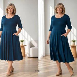 Op de afbeelding: Tealkleurige jurk met een ronde hals en driekwartmouwen. De jurk heeft een uitlopende rok met zakken en valt tot halverwege de kuit. Het model draagt beige hakken. Het woord "TEAL" staat onderaan de afbeelding.