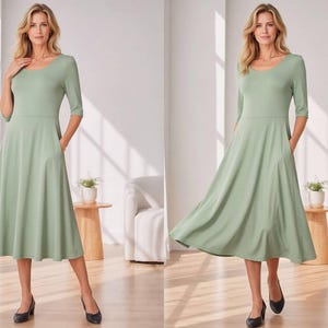 Op de afbeelding: Saliegroene midi-jurk met een ronde hals en driekwartmouwen. De jurk heeft een getailleerd lijfje, een gedefinieerde taille en een uitlopende rok met zakken. De zoom valt onder de knie&euml;n. Het woord "SAGE" staat rechtsonder gedrukt.