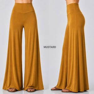 Puede incluir: Pantalones palazzo de talle alto en color amarillo mostaza con silueta de pierna ancha. La prenda presenta una tela lisa de color s&oacute;lido que cae holgadamente desde la cintura hasta el suelo. El texto MUSTARD aparece entre las dos vistas.