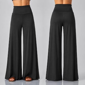 Puede incluir: Un par de pantalones negros lisos de talle alto y pernera ancha, mostrados desde la parte delantera y trasera. Los pantalones cuentan con una cintura lisa y ajustada sobre las caderas y caen en perneras sueltas hasta el suelo con dobladillo.