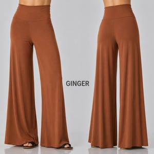 Puede incluir: Pantalones anchos de color jengibre s&oacute;lido con dise&ntilde;o de cintura alta y acabado de tela lisa. La prenda se muestra desde las perspectivas frontal y trasera, exhibiendo una silueta larga y fluida que llega hasta el suelo.