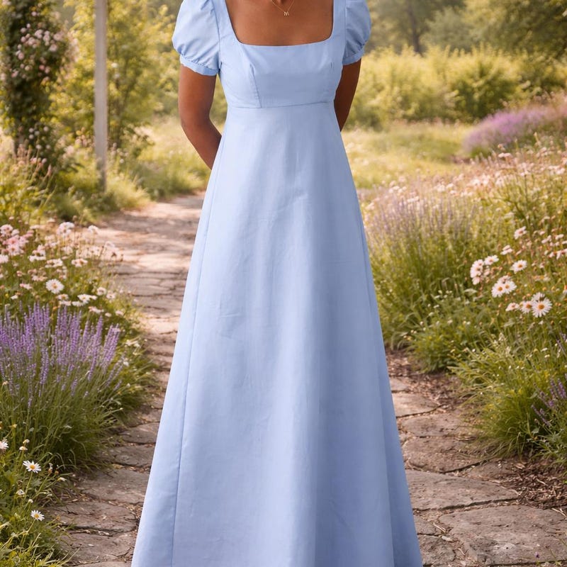 Simple light blue empire-waist gown with a square neckline, short puff sleeves, and a flowing skirt