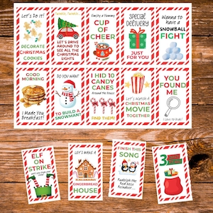 May include: A set of Christmas-themed cards with red and white borders. Each card features festive illustrations and text like "Decorate Christmas Cookies," "Cup of Cheer," and "Elf on Strike." The cards are arranged on a wooden surface.