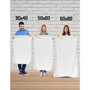 May include: Three white towels of different sizes, 76x102 cm, 127x152 cm, and 152x203 cm, are held up by three people in front of a white brick wall.