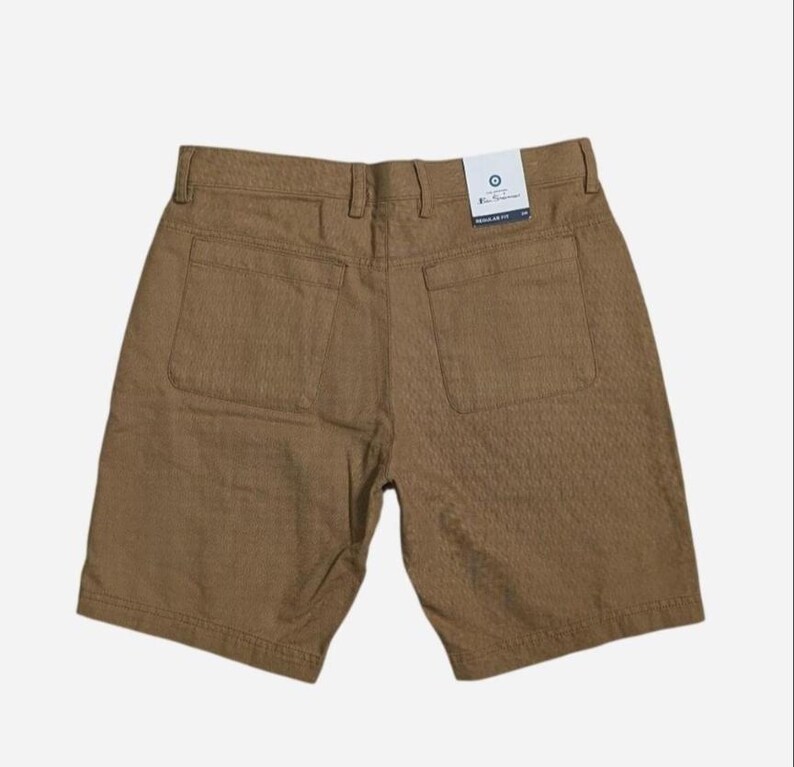 May include: Brown shorts with two back pockets and a textured pattern. The shorts have a tag that reads "Ben Sherman" and "Regular Fit".