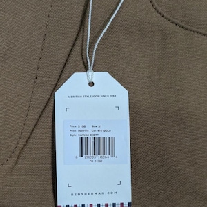 May include: A clothing tag for canvas shorts, with the text "A BRITISH STYLE ICON SINCE 1963". The tag displays the price, size 31, product and color codes, and the style "CANVAS SHORT". The brand name is BENSHERMAN.COM.