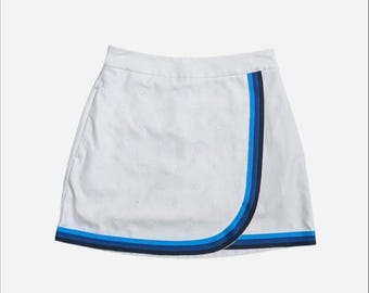 G/FORE Carrington Embroidered Golf Skort in white featuring a faux-wrap design with blue contrast trim and embroidered logo details size 0