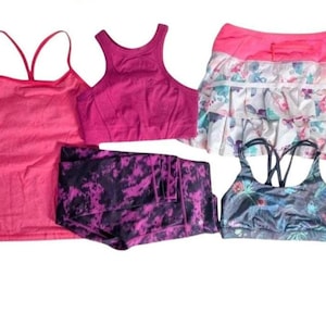 May include: A white ceramic mug with a black handle and the text "But First, Coffee" in a black, handwritten-style font. The mug is on a white surface.