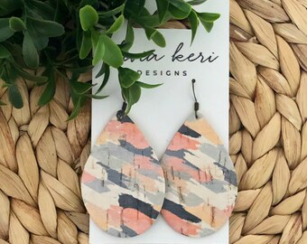 May include: A pair of teardrop-shaped earrings with a colorful abstract pattern on a white card with the text "Lana Keri Designs".