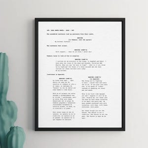 May include: A framed black and white print with a script. The text includes dialogue and stage directions, likely from a play or film. The print is mounted in a black frame and displayed on a white background.