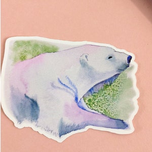 May include: A watercolor illustration of a polar bear lying down with its mouth open, surrounded by green foliage. The bear is painted in shades of white, blue, and purple.