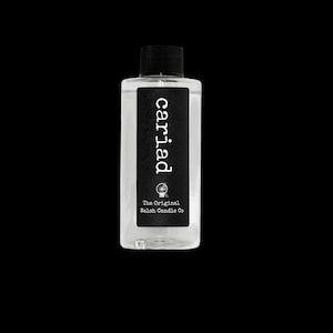 Puede incluir: Una botella de plástico transparente con tapón de rosca negro y una etiqueta rectangular negra. La etiqueta presenta el texto blanco "cariad" en fuente de máquina de escribir, un pequeño icono circular y el texto "The Original Welsh Candle Co".