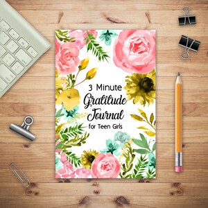 May include: A white journal cover with a floral design featuring pink, yellow, and green watercolor flowers. The text "3 Minute Gratitude Journal for Teen Girls" is printed in black.