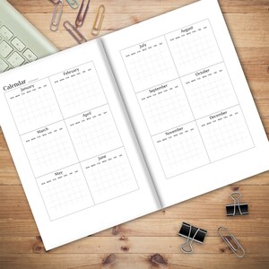 May include: A black and white calendar planner with a grid layout for each month of the year. The calendar is open to July and August. The months are labeled with the month name and the days of the week.