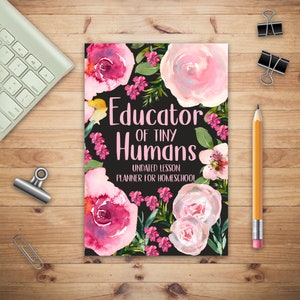 Puede incluir: Un planificador negro con diseños florales rosas y el texto "Educator of Tiny Humans Undated Lesson Planner for Homeschool"