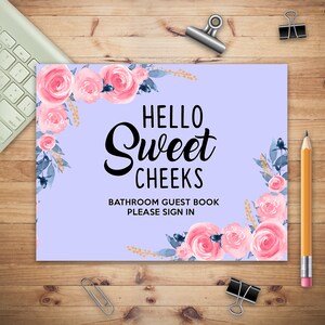 May include: A light purple sign with a floral border and the text "Hello Sweet Cheeks Bathroom Guest Book Please Sign In".