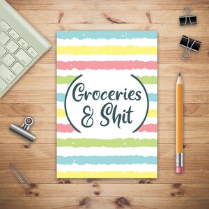 May include: A white notepad with a colorful striped background and the text "Groceries & Shit" in a black circle.
