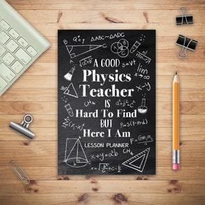 Könnte beinhalten: Ein schwarzer Stundenplaner mit weißem Text, der lautet: "A Good Physics Teacher Is Hard To Find But Here I Am." Der Planer ist von einem Bleistift, Büroklammern und einer Tastatur auf einem Holzschreibtisch umgeben.